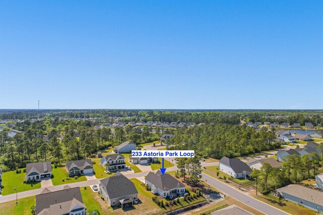 community pool with a patio, fence, and view of wooded area