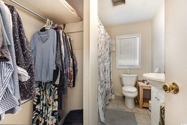 bathroom with vanity, toilet, tile patterned flooring, and curtained shower