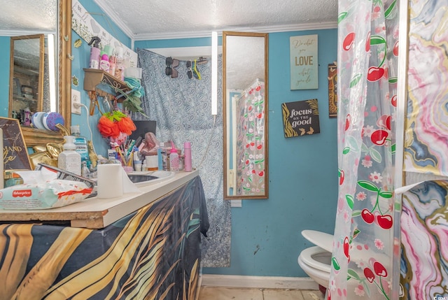 bathroom with toilet, vanity, crown molding, baseboards, and a textured ceiling