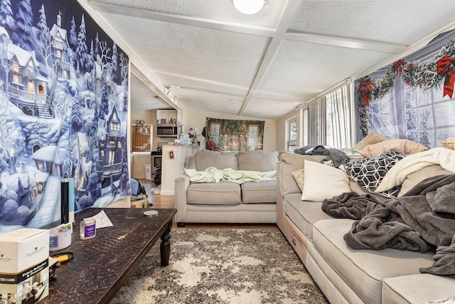living area with beamed ceiling, wood finished floors, and a textured ceiling