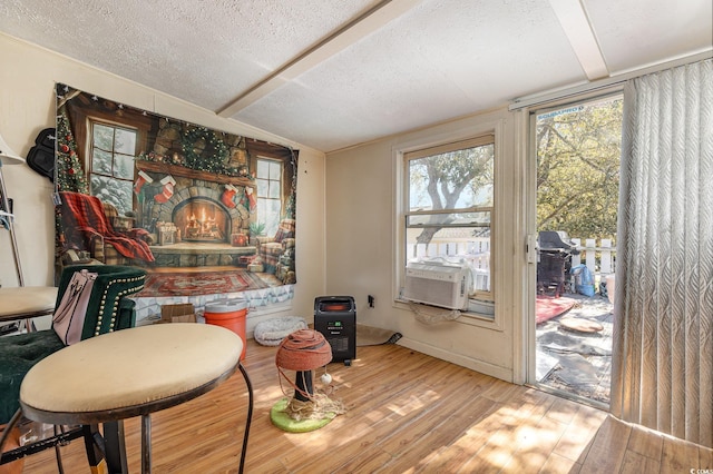 dining area with baseboards, wood finished floors, a textured ceiling, and cooling unit