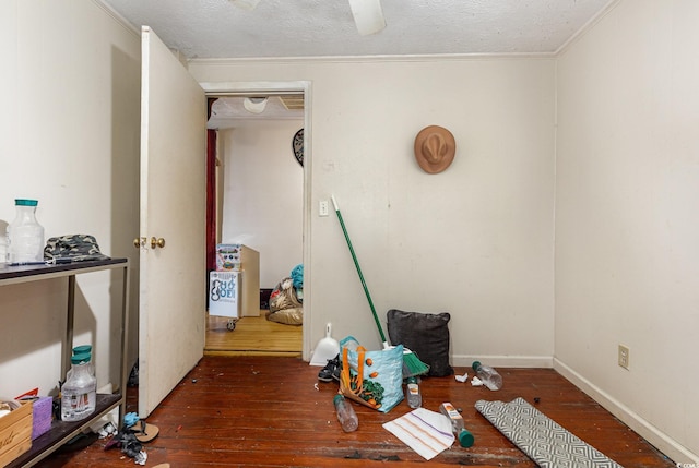 miscellaneous room featuring wood-type flooring, ornamental molding, and a textured ceiling