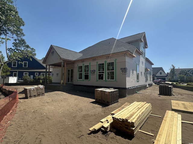 rear view of property with central air condition unit and a shingled roof