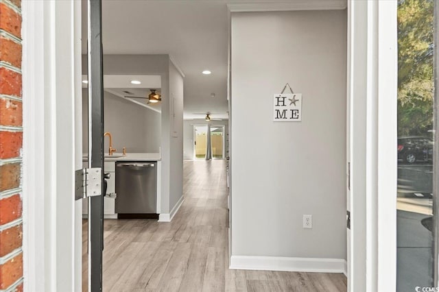 corridor with a sink, baseboards, recessed lighting, and light wood-style flooring