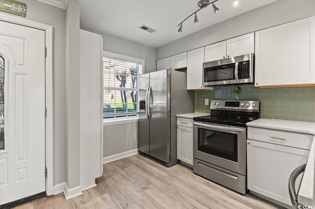 kitchen featuring decorative backsplash, visible vents, light countertops, light wood finished floors, and stainless steel appliances