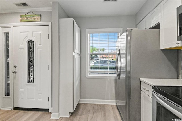 interior space featuring baseboards, light wood-style flooring, and visible vents