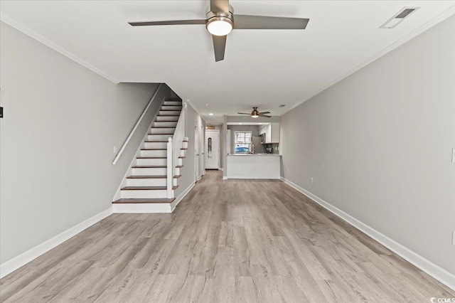 unfurnished living room featuring light wood finished floors, stairs, a ceiling fan, baseboards, and visible vents