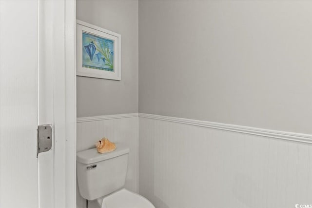 bathroom featuring toilet and wainscoting