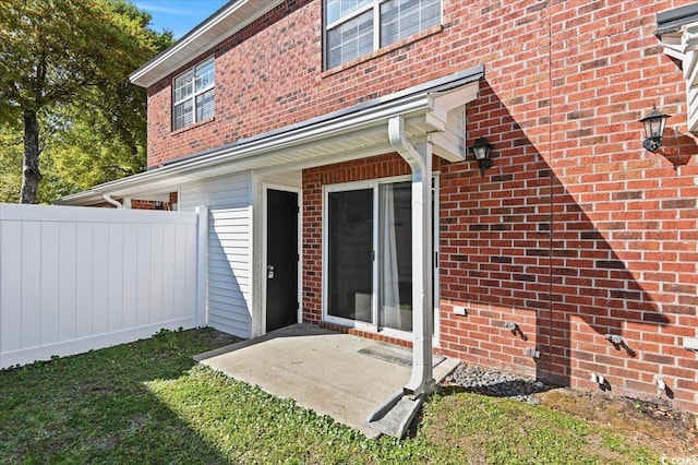 rear view of house with brick siding and fence