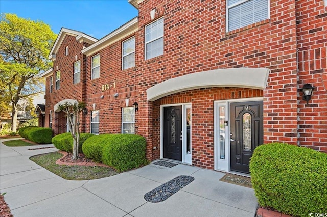 doorway to property featuring brick siding