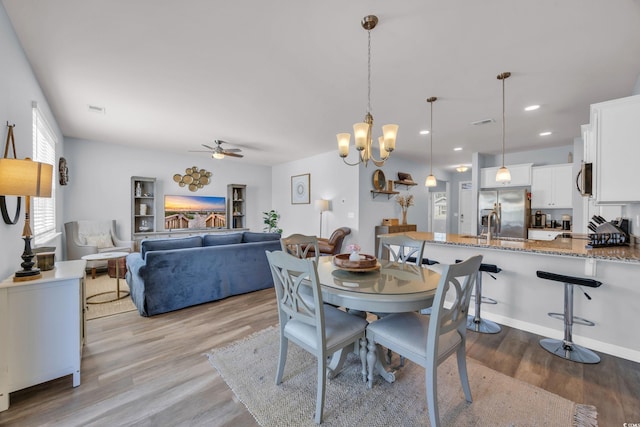 2771 Eclipse Dr, Myrtle Beach, SC 29577 - dining space with wood finished floors, ceiling fan, recessed lighting, and a chandelier