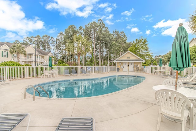 community pool featuring fence and a patio area