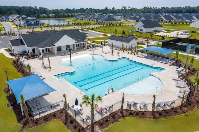 community pool featuring fence and a residential view