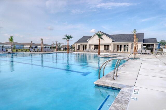 community pool featuring french doors, a patio area, and fence