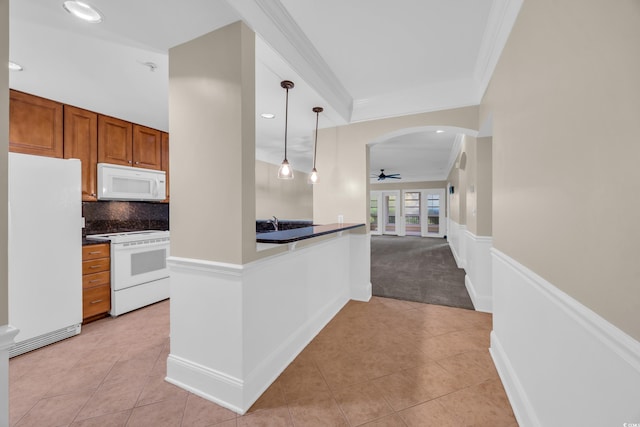kitchen featuring light tile patterned flooring, a ceiling fan, white appliances, brown cabinets, and ornamental molding