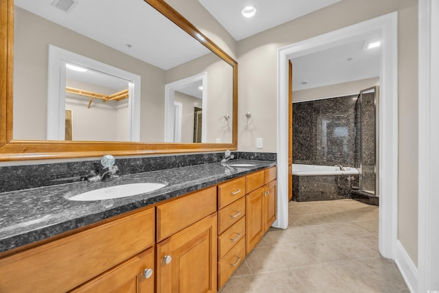 full bath featuring tile patterned floors, visible vents, a sink, and a tub with marble appearance