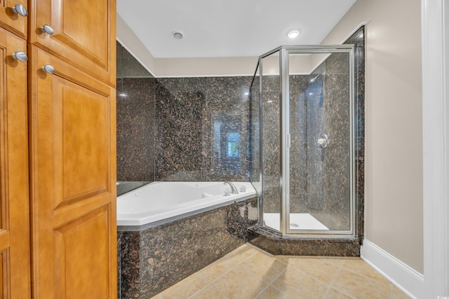 full bath with baseboards, a garden tub, tile patterned floors, and a stall shower
