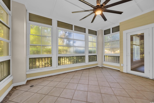 unfurnished sunroom featuring a wealth of natural light, tile patterned flooring, and baseboards