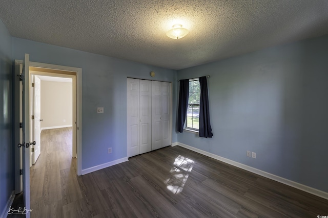 409 5th Ave S Unit 409, Surfside Beach, SC 29575 - unfurnished bedroom featuring dark wood-type flooring, a textured ceiling, a closet, and baseboards