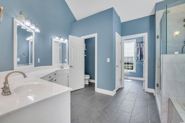 full bath with double vanity, marble finish floor, toilet, a sink, and a stall shower