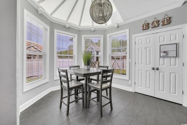 dining area with dark tile patterned flooring, baseboards, and ornamental molding