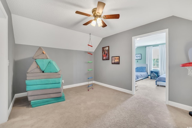 interior space with carpet floors, baseboards, a ceiling fan, and lofted ceiling