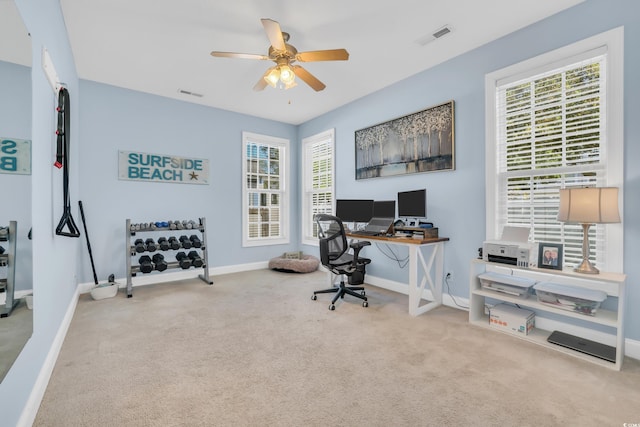 carpeted office featuring baseboards, visible vents, and ceiling fan