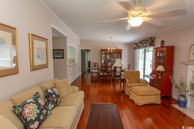 living area featuring wood finished floors, a textured ceiling, ornamental molding, and ceiling fan with notable chandelier