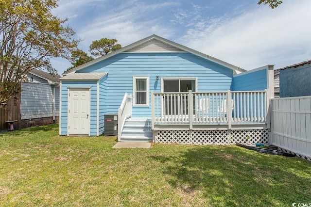 back of property with a lawn, central AC, fence, and a deck