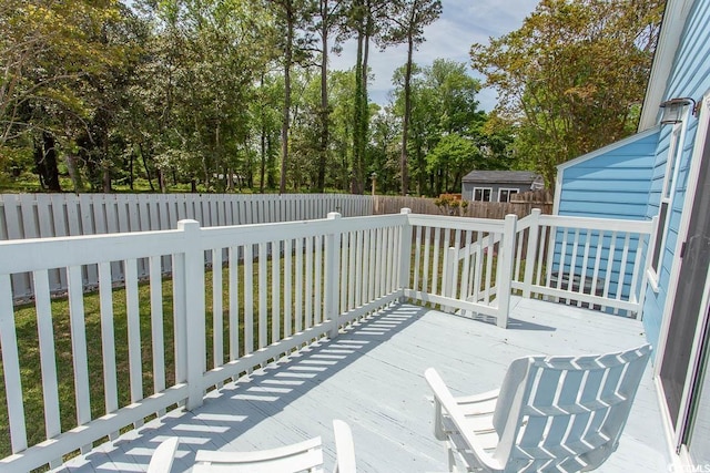 deck featuring a fenced backyard, an outbuilding, a yard, and a storage shed