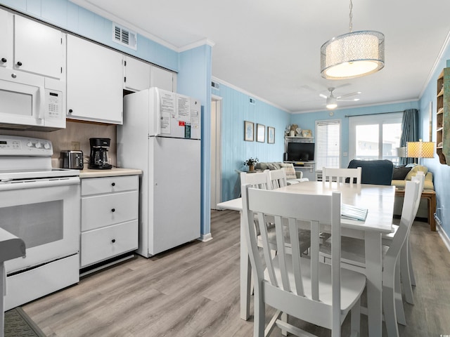 5000 N Ocean Blvd Unit B-1, North Myrtle Beach, SC 29582 - dining space with crown molding, a ceiling fan, visible vents, and light wood-type flooring