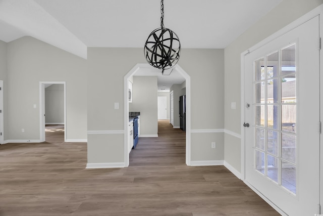 202 Berkshire Dr, Myrtle Beach, SC 29588 - unfurnished dining area with vaulted ceiling, baseboards, a notable chandelier, and wood finished floors