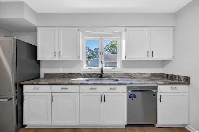 202 Berkshire Dr, Myrtle Beach, SC 29588 - kitchen featuring white cabinets, a sink, light wood-type flooring, dark stone counters, and appliances with stainless steel finishes