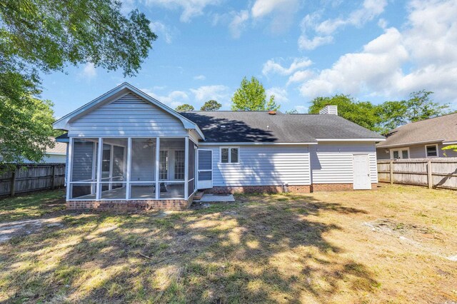 202 Berkshire Dr, Myrtle Beach, SC 29588 - rear view of house with a fenced backyard, a sunroom, a chimney, and a lawn