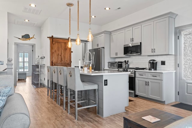 19 Red Skiff Ln Unit 15, Pawleys Island, SC 29585 - kitchen featuring appliances with stainless steel finishes, gray cabinets, a breakfast bar, and recessed lighting