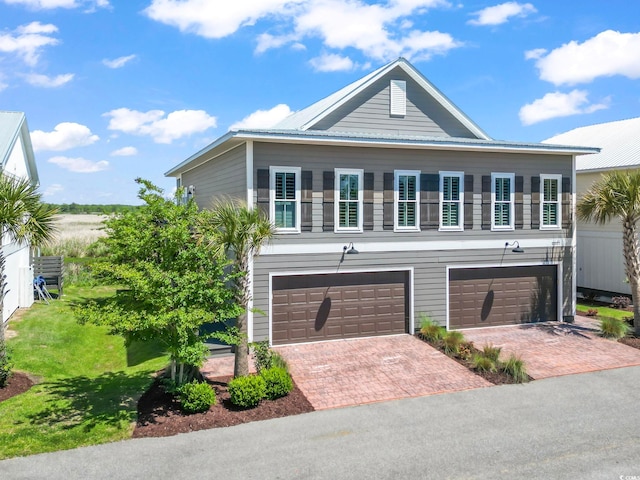 19 Red Skiff Ln Unit 15, Pawleys Island, SC 29585 - view of front of house with an attached garage, decorative driveway, a metal roof, and a front lawn