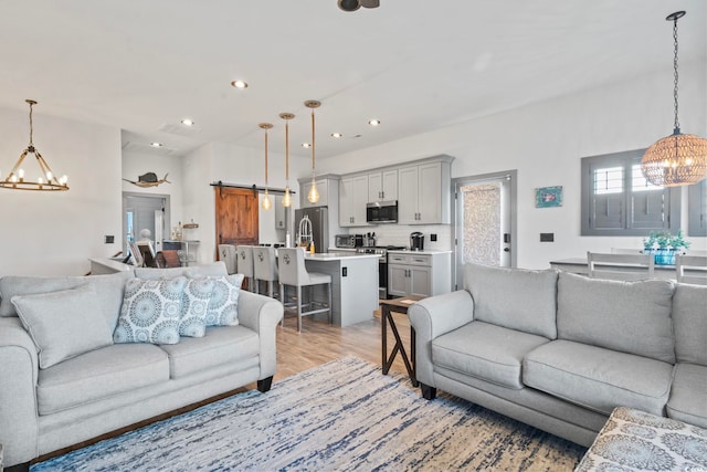 19 Red Skiff Ln Unit 15, Pawleys Island, SC 29585 - living area with a chandelier, a barn door, recessed lighting, and light wood-type flooring