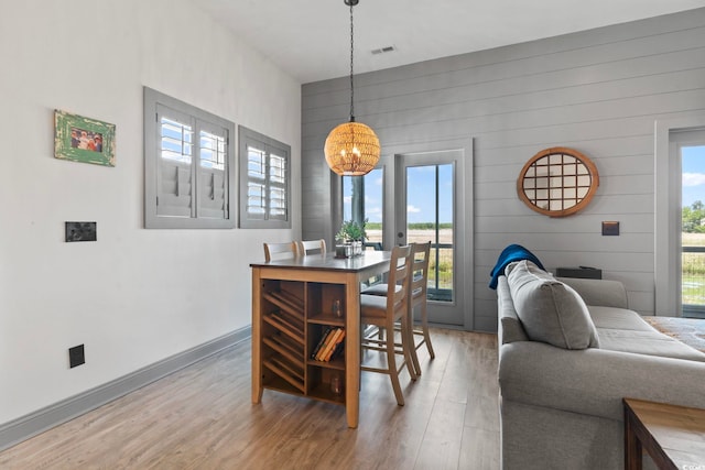 19 Red Skiff Ln Unit 15, Pawleys Island, SC 29585 - dining area with a chandelier, light wood-style floors, healthy amount of natural light, and wooden walls