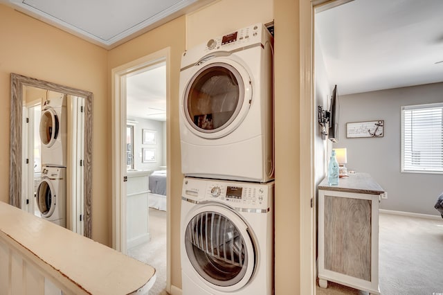 4504 S Ocean Blvd Unit A, North Myrtle Beach, SC 29582 - washroom featuring light colored carpet, stacked washer and clothes dryer, baseboards, and laundry area