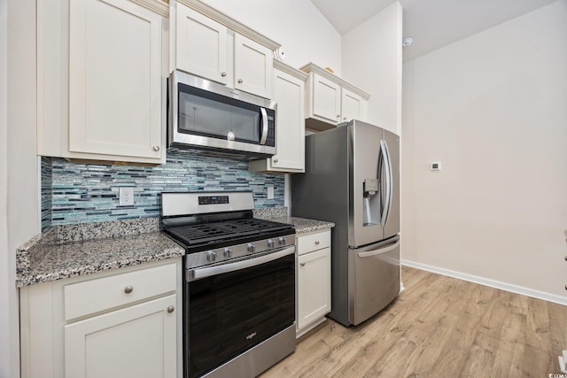 351 Logan St, Little River, SC 29566 - kitchen with stainless steel appliances, baseboards, backsplash, light wood-style floors, and light stone counters