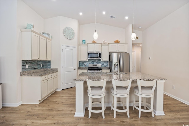351 Logan St, Little River, SC 29566 - kitchen featuring stainless steel appliances, tasteful backsplash, a sink, vaulted ceiling, and a center island with sink