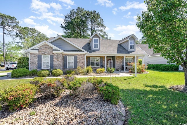 7011 Blade Beak Ln, Myrtle Beach, SC 29588 - view of front of property with covered porch, brick siding, a front yard, and roof with shingles