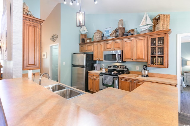 7011 Blade Beak Ln, Myrtle Beach, SC 29588 - kitchen featuring a sink, glass insert cabinets, a high ceiling, brown cabinetry, and appliances with stainless steel finishes