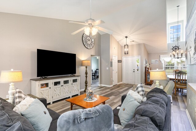 7011 Blade Beak Ln, Myrtle Beach, SC 29588 - living room with baseboards, wood finished floors, high vaulted ceiling, and ceiling fan with notable chandelier