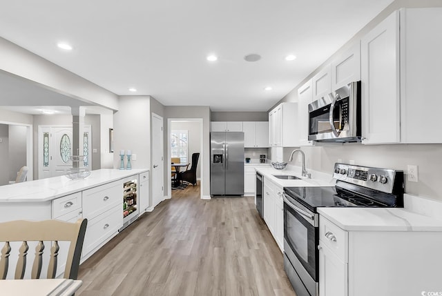 130 Ashton Cir, Myrtle Beach, SC 29588 - kitchen featuring a sink, light wood-style floors, stainless steel appliances, white cabinetry, and wine cooler