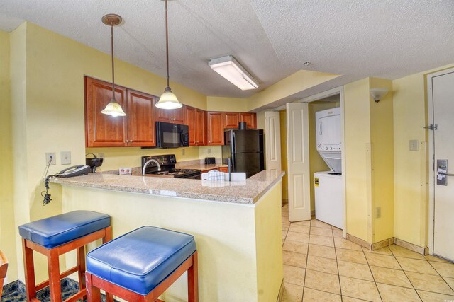 5300 N Ocean Blvd Unit 923, Myrtle Beach, SC 29577 - kitchen with a peninsula, stacked washing maching and dryer, a textured ceiling, black appliances, and light countertops