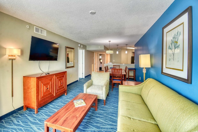carpeted living area with a textured ceiling, baseboards, and visible vents