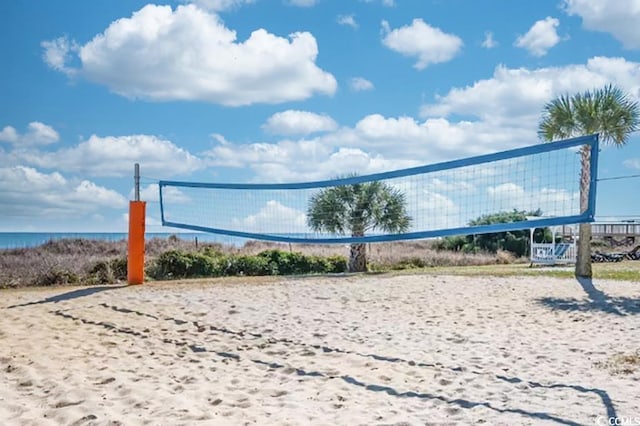 surrounding community with a water view and volleyball court
