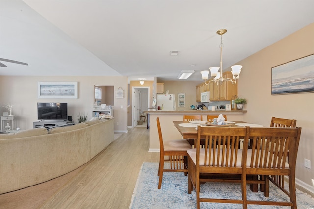 dining room featuring light wood finished floors, visible vents, baseboards, and ceiling fan with notable chandelier