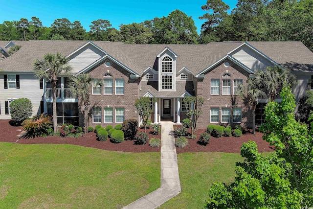 view of front of home with a front lawn and brick siding